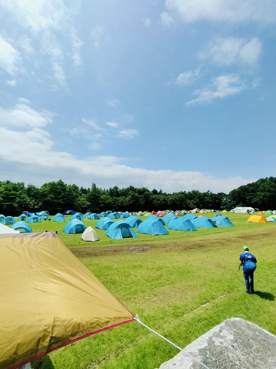 青空の下、テントが立ち並ぶキャンプ場
